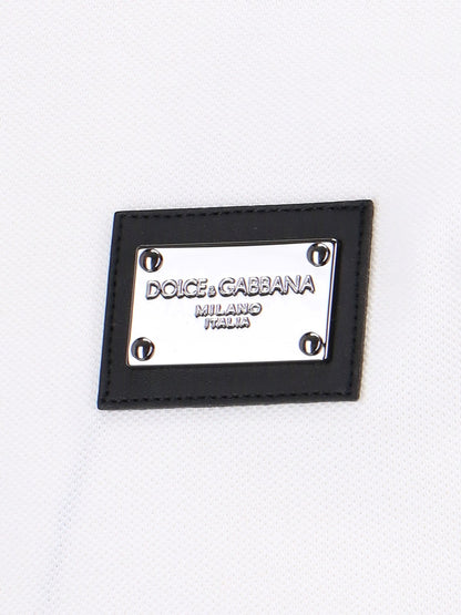 Dolce & Gabbana T-Shirt patch logo-t-shirt-Dolce & Gabbana-T-shirt patch logo Dolce & Gabbana, in cotone bianco, colletto classico, chiusura bottoni, maniche corte, orlo dritto.-Dresso