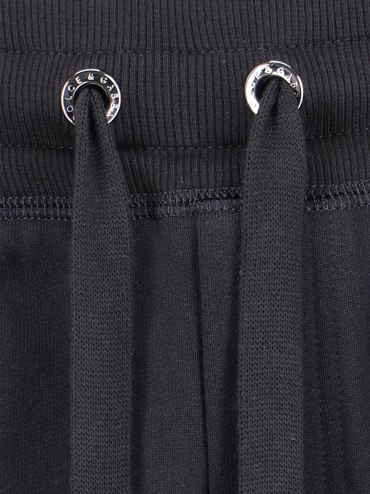 Dolce & Gabbana Pantaloni sportivi logo-Pantaloni sportivi-Dolce & Gabbana-Pantaloni sportivi logo Dolce & Gabbana, in cotone nero, vita elastica, coulisse, due tasche zip laterali, una tasca zip retro, placca logo metallico argentato retro, polsini elastici.-Dresso