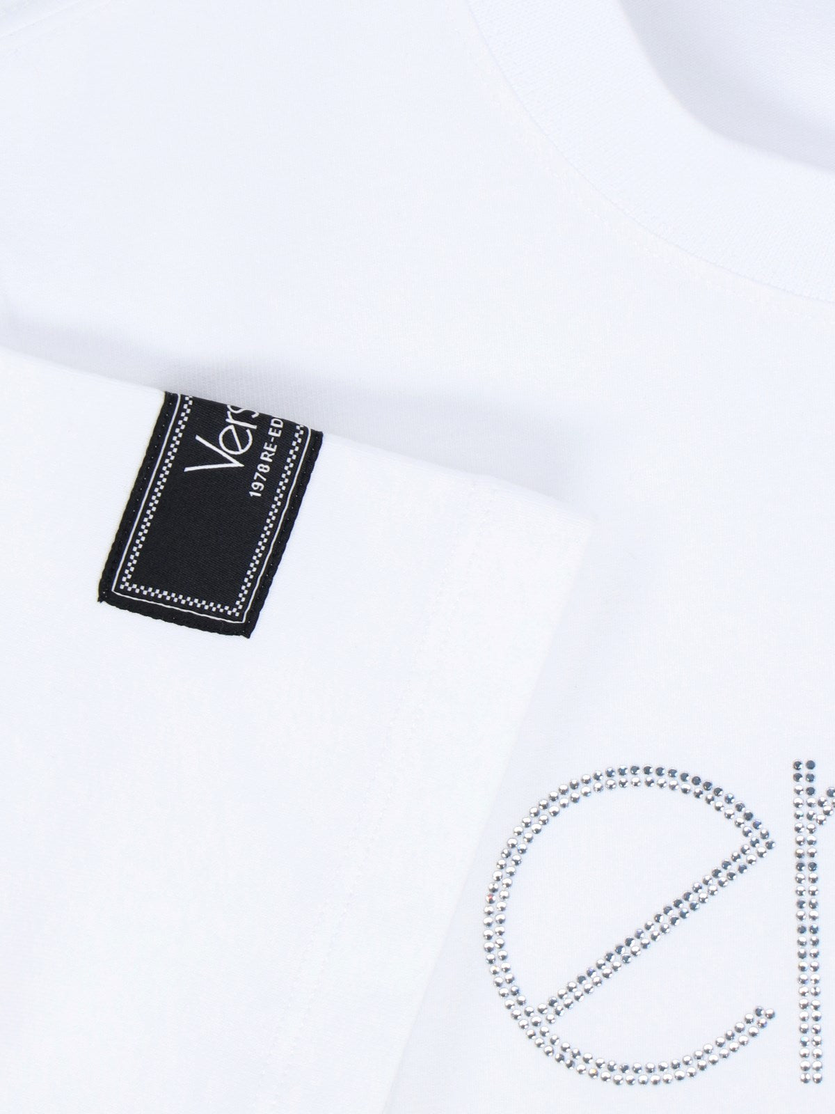 Versace T-Shirt "1978 Re-Edition Logo"-t-shirt-Versace-T-shirt "1978 re-edition logo" Versace, in misto cotone bianco, girocollo, maniche corte, dettaglio etichetta a contrasto applicata manica, logo cristalli fronte, orlo dritto.-Dresso